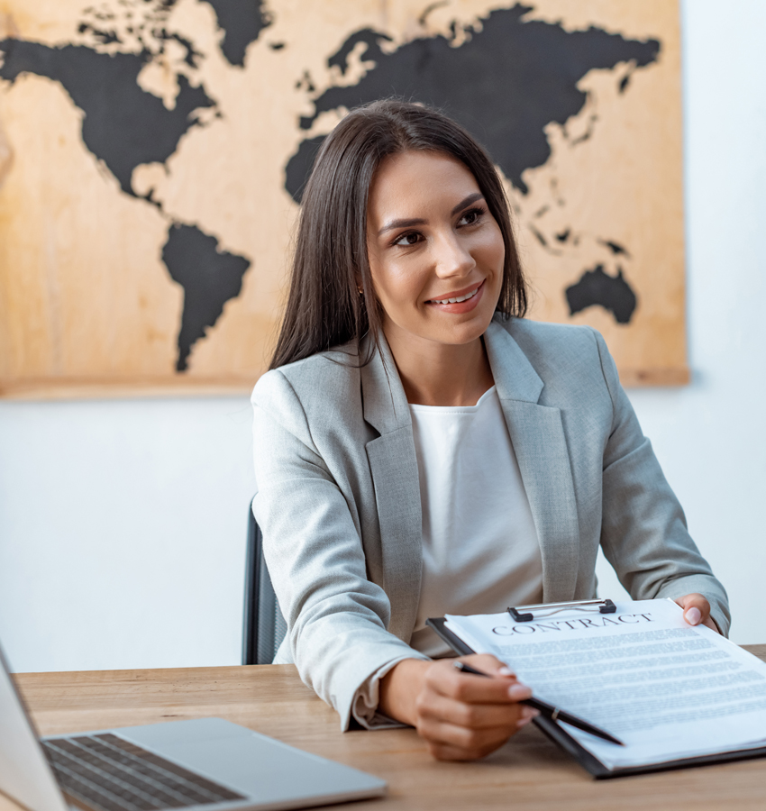 smiling travel agent showing signature place in contract to clie